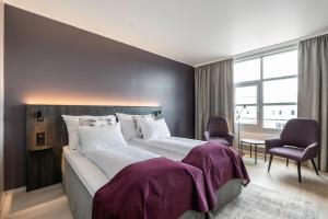Quality Airport Hotel Værnes في ستويدل: غرفة نوم مع سرير كبير مع ملاءات أرجوانية