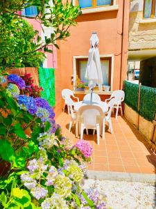 un patio con mesa, sillas y flores en Vivienda turística Porta do Sol, en Baiona