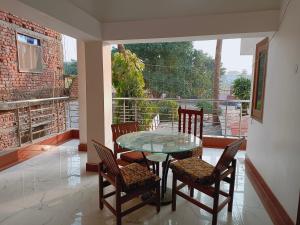a dining room with a glass table and chairs on a balcony at The Gupta Guest House in Bodh Gaya