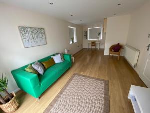 un soggiorno con divano verde in una camera di Isle of Anglesey Spacious Home a Llanfairpwllgwyngyll