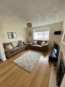 a living room with two couches and a television at Isle of Anglesey Spacious Home in Llanfairpwllgwyngyll