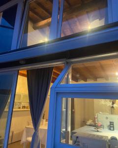 a house with blue windows and a table with a table at La casa di Angelina in Salò