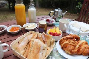 a table with a breakfast of bread and croissants and orange juice at Chambre d'hôtes Les terrasses de Saint Clair in Sète