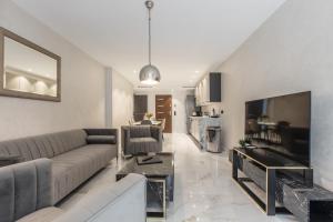 un soggiorno con un divano e una TV di Résidence Topaze - Central - Luxurious - 50m Croisette Palais - LRA CANNES a Cannes
