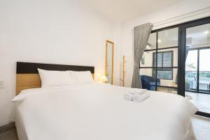 a large white bed in a room with a large window at Arista in Ho Chi Minh City