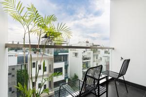 a balcony with two chairs and a plant at Arista in Ho Chi Minh City