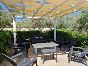 un patio avec une table et des chaises sous un toit en bois dans l'établissement Appartamenti Mirante, à Campomarino