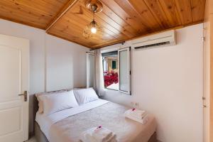 Cama en habitación pequeña con ventana en Melas Home, en Lefkada