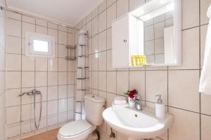 Baño blanco con aseo y lavamanos en Melas Home, en Lefkada