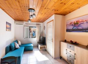 sala de estar con sofá azul y TV en Melas Home, en Lefkada