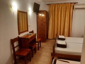 a room with a bed and a table and a desk at Hotel Kosmas in Sarti