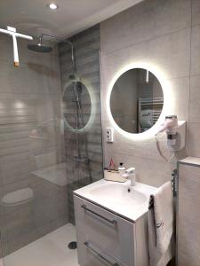 uma casa de banho com um lavatório, um chuveiro e um espelho. em Zagreb4you Apartments em Zagreb