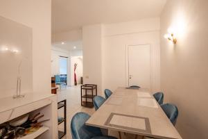 une salle à manger avec une grande table et des chaises bleues dans l'établissement La Sapienza APT, à Rome