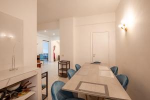 a dining room with a long table and blue chairs at La Sapienza APT in Rome