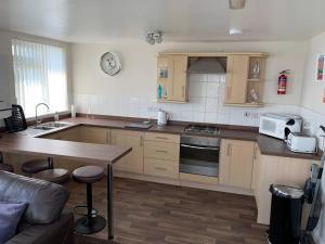 a kitchen with wooden cabinets and a counter top at Vista Apartments, Goodrington Beach, Paignton in Paignton