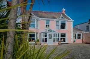 uma casa cor-de-rosa com portas e janelas brancas em Potters Mooring Hotel em Teignmouth