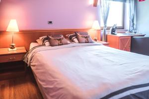 a bedroom with a large white bed with pillows at Hotel Au Coeur de Lacuisine in Florenville