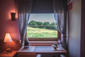 una camera con finestra affacciata su un campo di Hotel Au Coeur de Lacuisine a Florenville