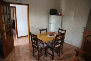 a kitchen with a table and chairs and a refrigerator at Alojamento, Chelas Rural AL in Mirandela