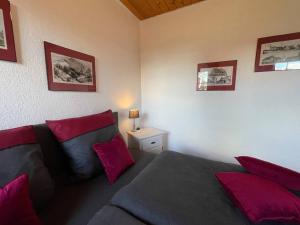 ein Schlafzimmer mit einem Bett mit roten Kissen in der Unterkunft Huuske Lütten Uttied - Das Landleben genießen in Moormerland