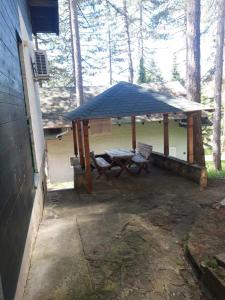 un refugio de picnic con una mesa de picnic y un banco en Zeleni raj en Vrnjačka Banja