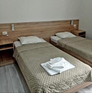 two beds in a hotel room with towels on them at Hotel Giorgi in Tsqaltubo