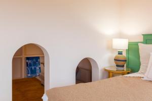 um quarto com uma cama e uma mesa com um candeeiro em Villa Riu Blanc em Benissa