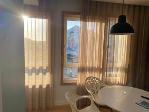 jadalnia ze stołem i krzesłami oraz oknem w obiekcie Altamira GB w mieście Estarreja
