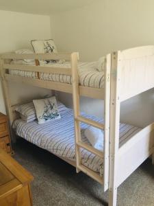 kilka łóżek piętrowych w pokoju w obiekcie The Wheel House w mieście Mevagissey