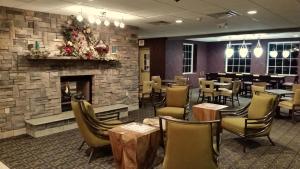 a restaurant with a fireplace and tables and chairs at Wingate by Wyndham Elkins in Elkins