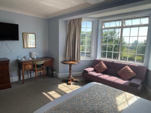a living room with a couch and a desk and window at Yellow Mountain Hotel in Skegness