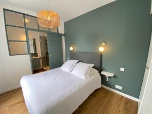 um quarto com uma cama branca e um espelho em Hotel Saint-Michel em Dinard