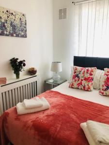a bedroom with a bed with a red blanket at Super location 2, 1min metro 10 min from Camden in London
