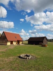 a barn with a fire pit in the middle of a field at Oaza spokoju in Ramsówko