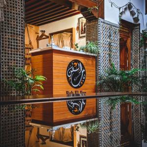 una señal en el lado de un edificio con plantas en Riad & Café culturel BAB EL FAN en Tetuán