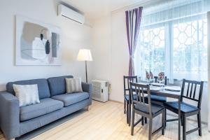 ein Wohnzimmer mit einem blauen Sofa, einem Tisch und Stühlen in der Unterkunft Two bedroom home in Jewish quarter in Budapest