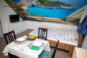 a room with a table and a bed with a painting on the ceiling at Orgonavirág Apartman in Hajdúszoboszló