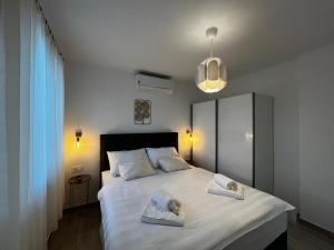 a bedroom with a large bed with two towels on it at Pekasovi Seaview Apartament on a beautiful island Krapanj in Šibenik