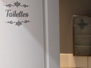 une porte avec un panneau indiquant les toilettes sur elle dans l'établissement Appartement au rez-de-chaussée Style industriel dans quartier calme, à Valliquerville