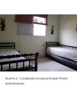 a bedroom with two beds and a window at Morada da praia - casa in Boracéia +27 photos