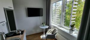 um quarto com uma grande janela com uma mesa e uma televisão em Pepleri Studio 68 em Tartu