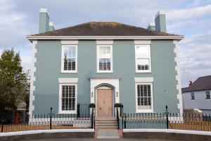 a blue house with a fence in front of it at John Lewis Apartment in Aberaeron
