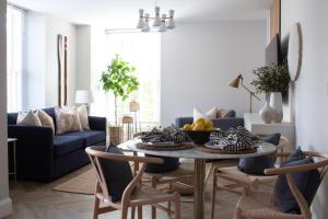 a living room with a table and a blue couch at John Lewis Apartment in Aberaeron