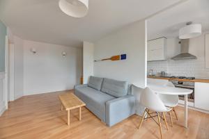 - un salon avec un canapé et une table dans l'établissement Grand Apartments - Apartament Surfer w centrum Sopotu, à Sopot