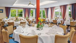a dining room with white tables and chairs at Hotel Juwel in Bad Füssing