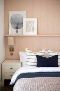 a bedroom with a bed with white and blue pillows at John Lewis Apartment in Aberaeron