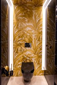 een badkamer met geel behang en een toilet bij Golden Eye Apartament Seaside Park in Kołobrzeg