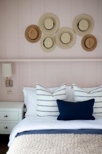 a bed with blue and white pillows and hats on the wall at John Lewis Apartment in Aberaeron