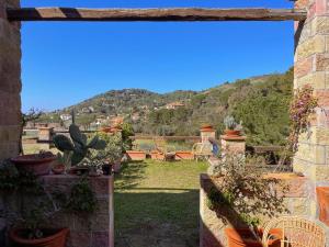 vista su un cortile con sedie e piante in vaso di Il Giardino del Volterraio a Rio nellʼElba