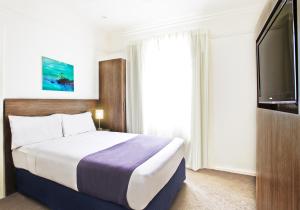 Tempat tidur dalam kamar di Cottesloe Beach Hotel